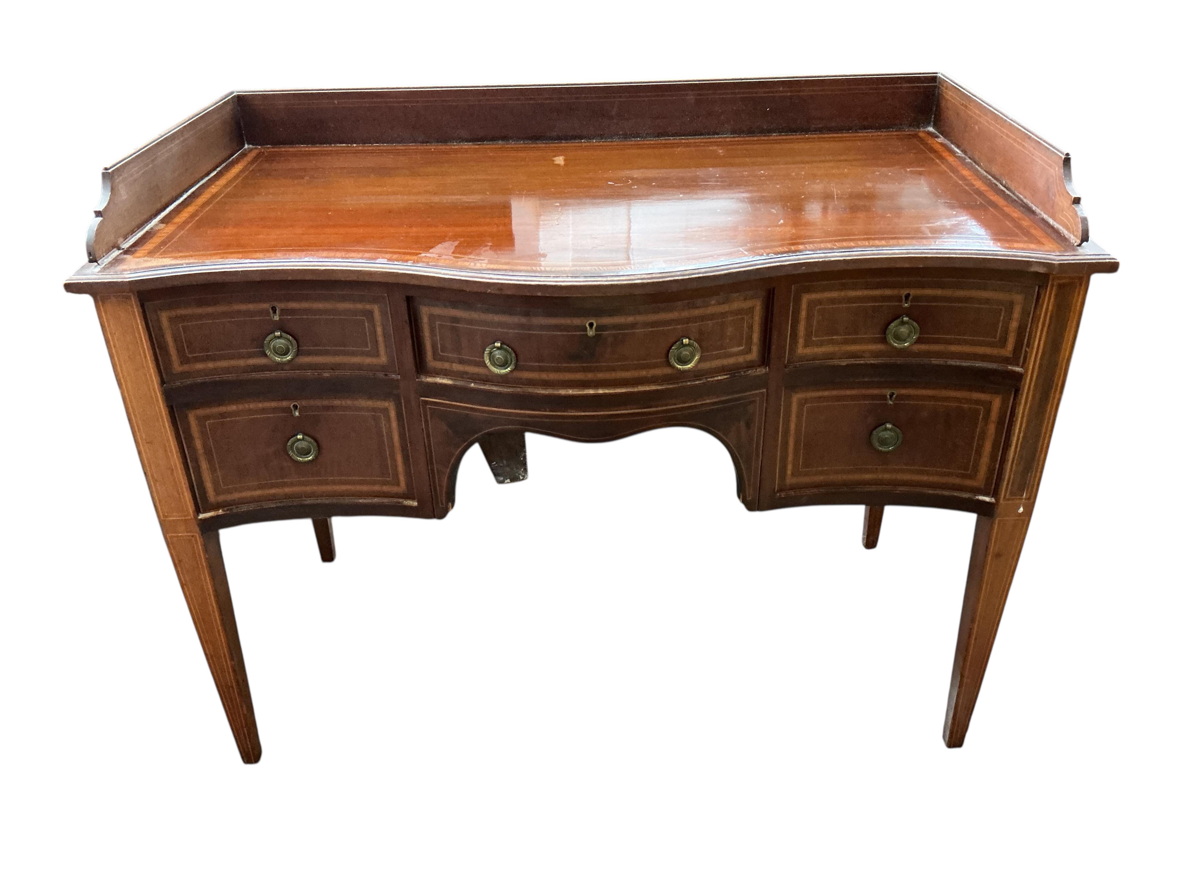 An Edwardian satinwood banded serpentine mahogany dressing table, on tapered legs, width 106cm, depth 54cm, height 82cm